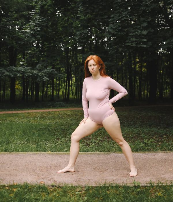 Person stretching gently outdoors, looking peaceful and refreshed.